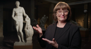 Eine Frau zeigt auf eine Statue der Aphrodite